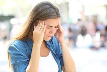  woman holding head suffering with migraine. Preston chiropractic associates can locate the source of the pain