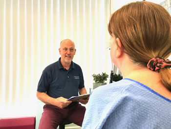 Jeff Shurr of Preston Chiropractic Associates in consultation with female patient