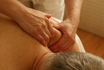 Chiropractic Associates sports therapist using manual massage on the shoulder of a male patient